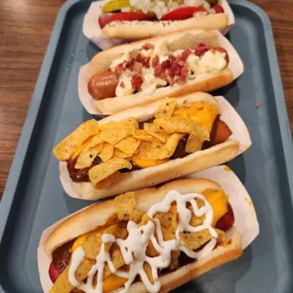Four Funky Franks hot dogs with various toppings, including bacon, cheese, and tortilla chips.