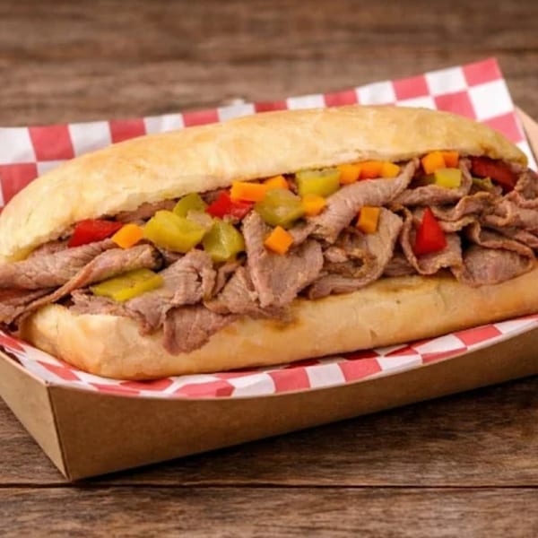 A Funky Franks Italian beef sandwich with giardiniera on a red and white checkered paper.